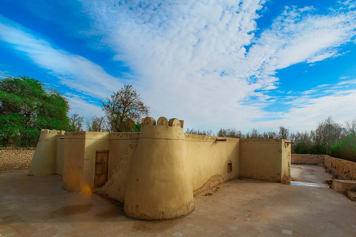 The low ruined mud-brick and stone walls of Jawatha Mosque in al-Ahsa, with the outlines of its aisles and a mihrab niche, under open sky.