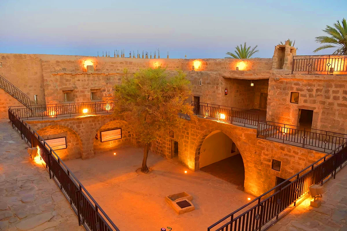 The square stone Ottoman castle in central Tabuk with plain high walls, corner towers and a single gateway, seen from outside in morning light.