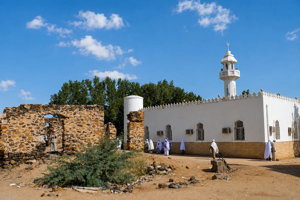 The flat open valley of al-Hudaybiyah, now al-Shumaisi, west of Makkah, low brown hills on the horizon and dry scrub in the foreground, with a small plain mosque standing alone in the middle distance.