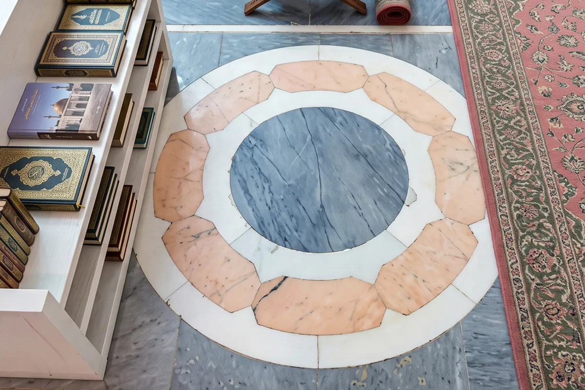 Patterned pale marble flooring inside the Prophet's Mosque in Madinah, with circular inset marble mosaics set into the paving, lit by warm even mosque lighting.
