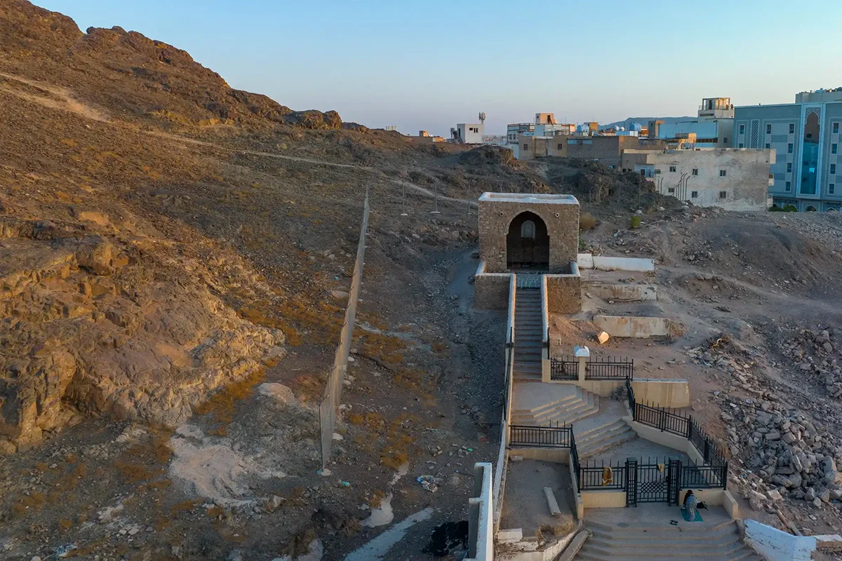 The rocky slopes of Mount Sela' rising above the built-up al-Fath neighbourhood northwest of Madinah, where the trench was dug, seen in warm late afternoon light.