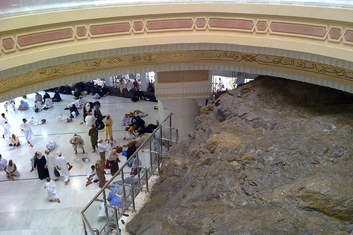 The marble expanse of the Masjid al-Haram courtyard beside the hill of Safa, where the house of al-Arqam once stood, pilgrims crossing as anonymous blurred shapes under the colonnade arches.